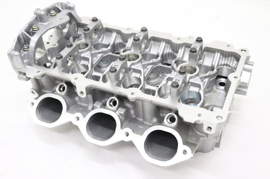 A Nissan cylinder head for model R35 GTR, showcasing various valve ports and engine components.