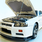 Installed FUJITSUBO EXH+ Hood Support holding open the hood of a Nissan Skyline GT-R BNR34, showcasing fitment and design.