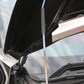Detailed view of FUJITSUBO EXH+ Hood Support rod with protective sticker and burnt titanium finish on Civic Type R FK8.