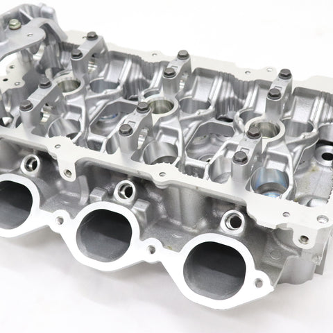 A Nissan cylinder head for model R35 GTR, showcasing various valve ports and engine components.